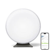 IQAir Atem X CF Luftreiniger, runde weiße Front, daneben Smartphone mit App-Anzeige der Luftwerte